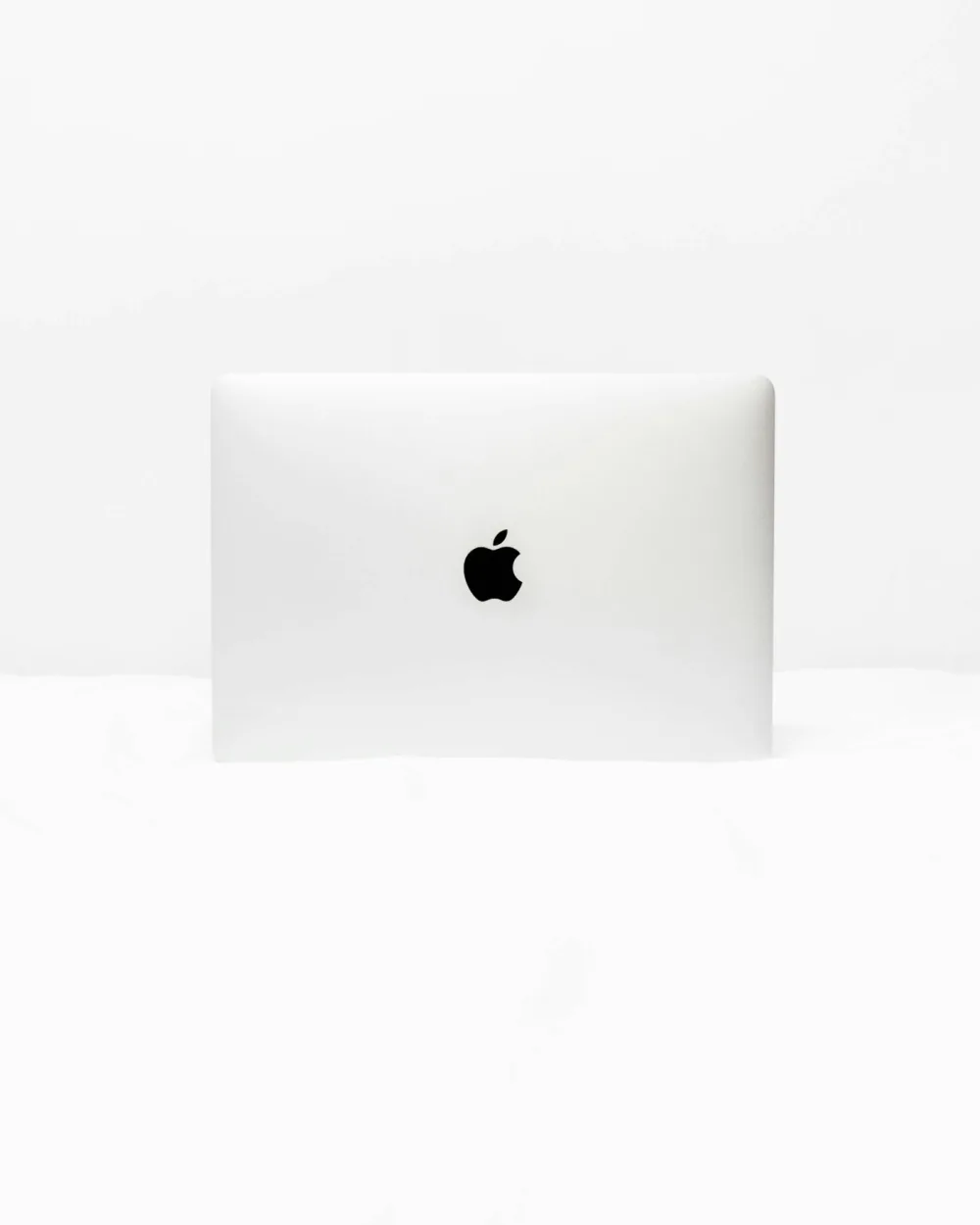 Notebook Apple plateada sobre un fondo blanco